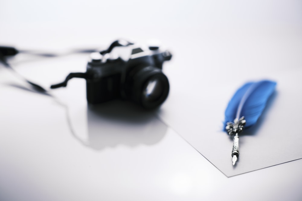 a camera and a pen on a table