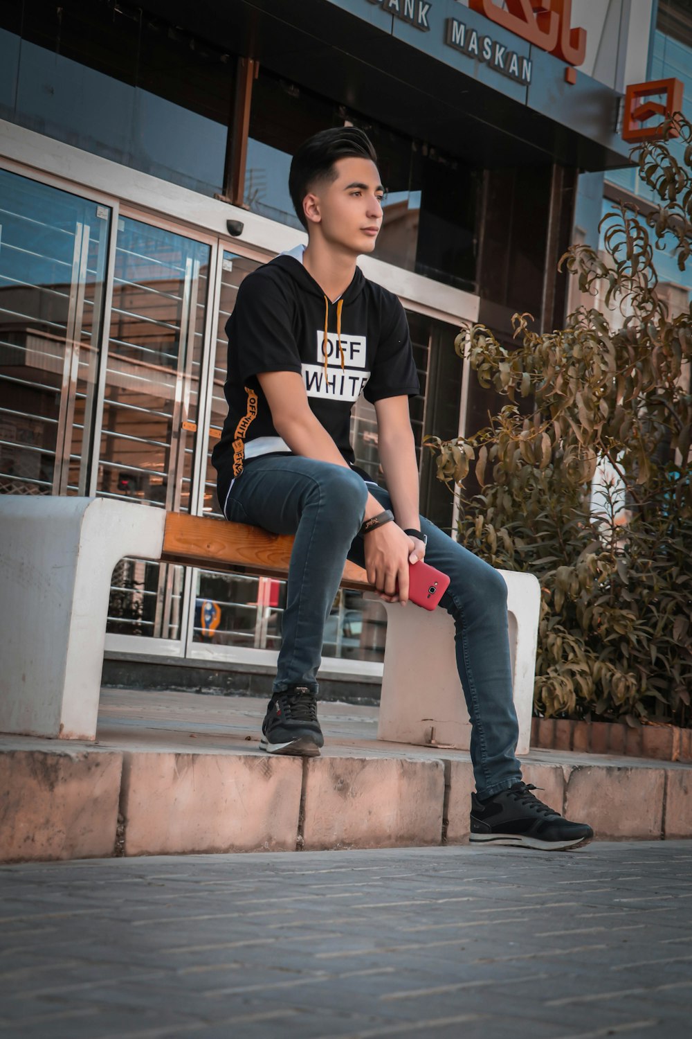 a man sitting on a bench outside of a building