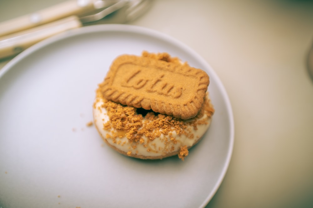 a white plate topped with a cookie on top of a doughnut