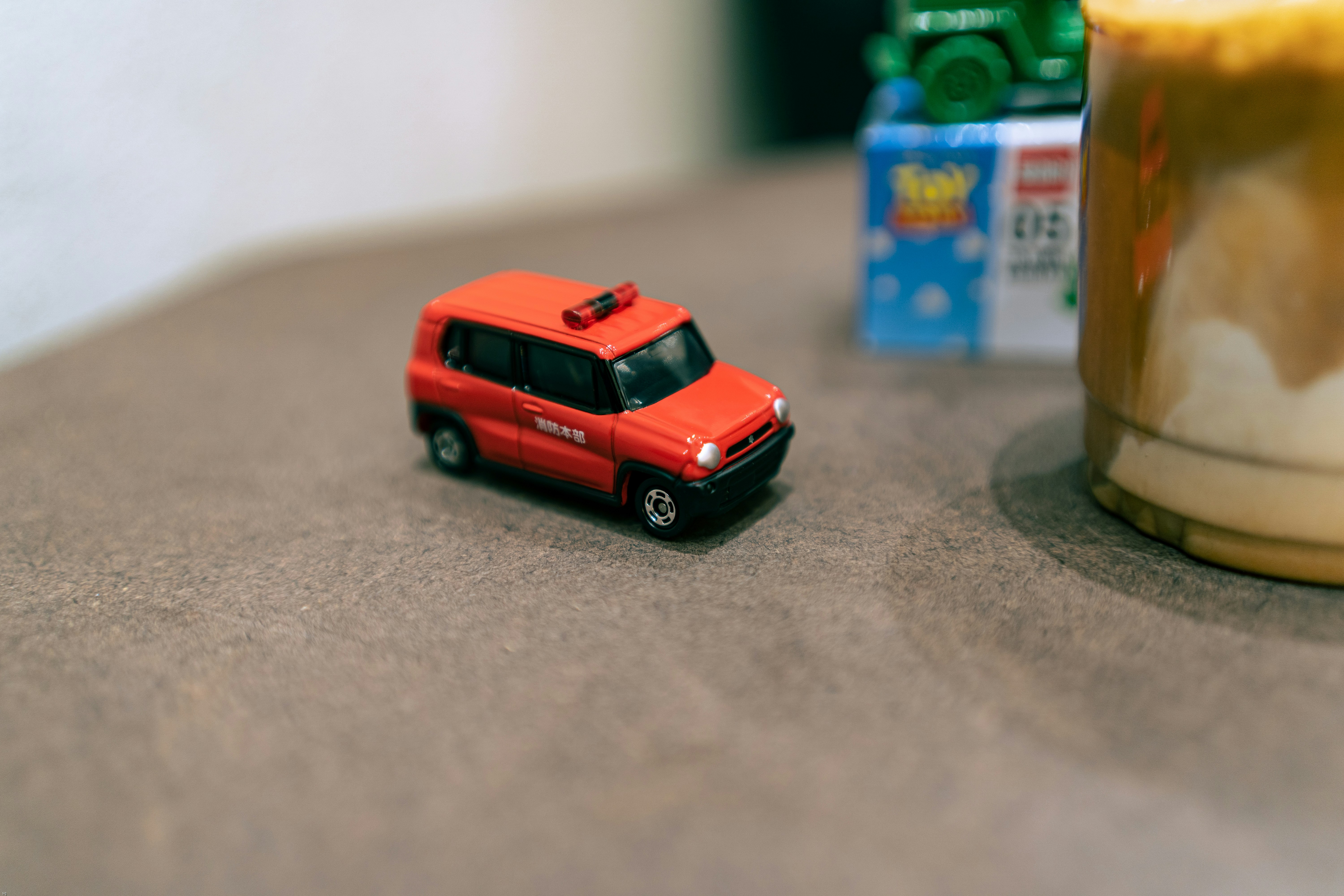 a red toy car sitting on top of a table