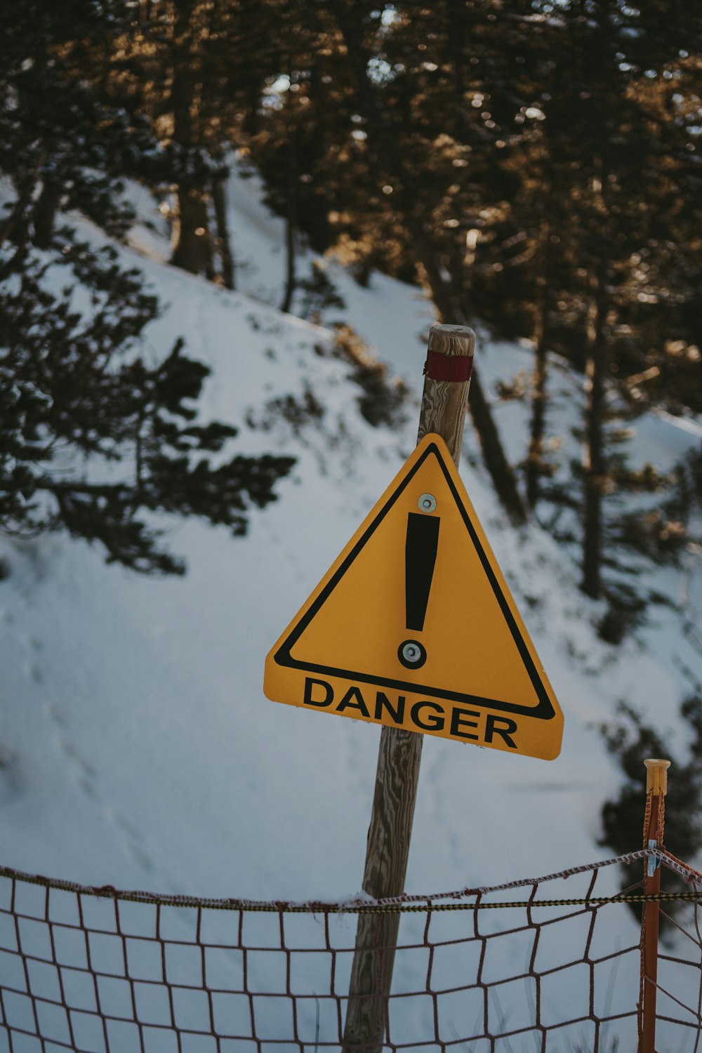 Una señal de advertencia en un poste de la cerca en la nieve