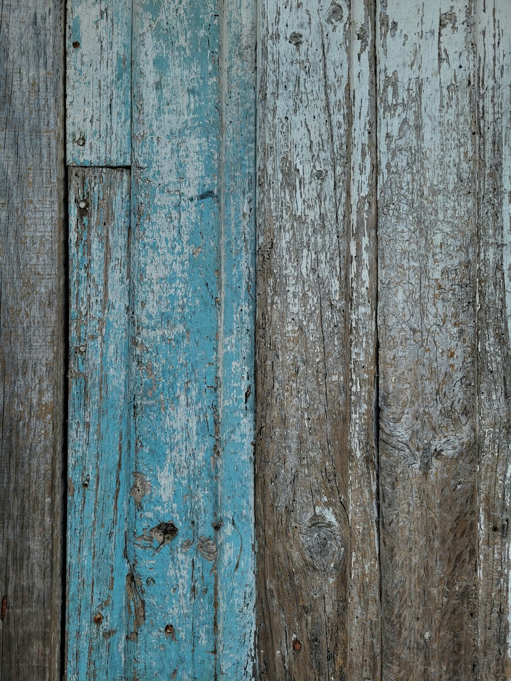 a wooden wall with peeling paint on it