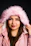 a woman wearing a pink jacket and a furry hat