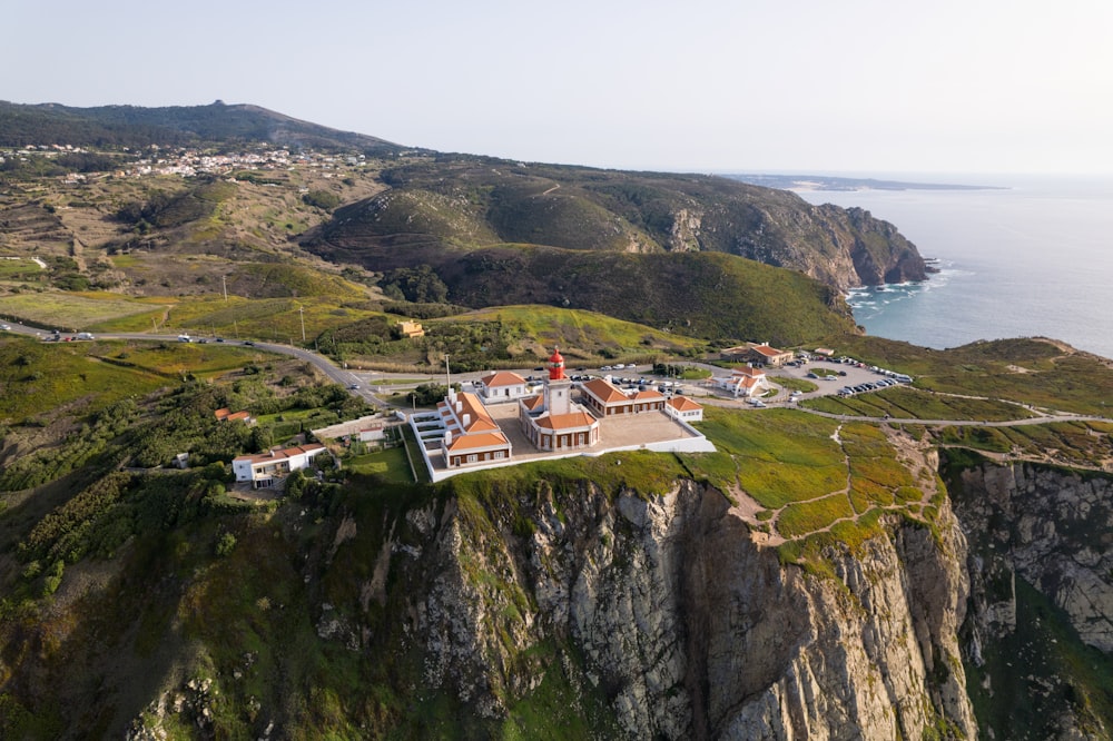 an aerial view of a house on a cliff overlooking the ocean