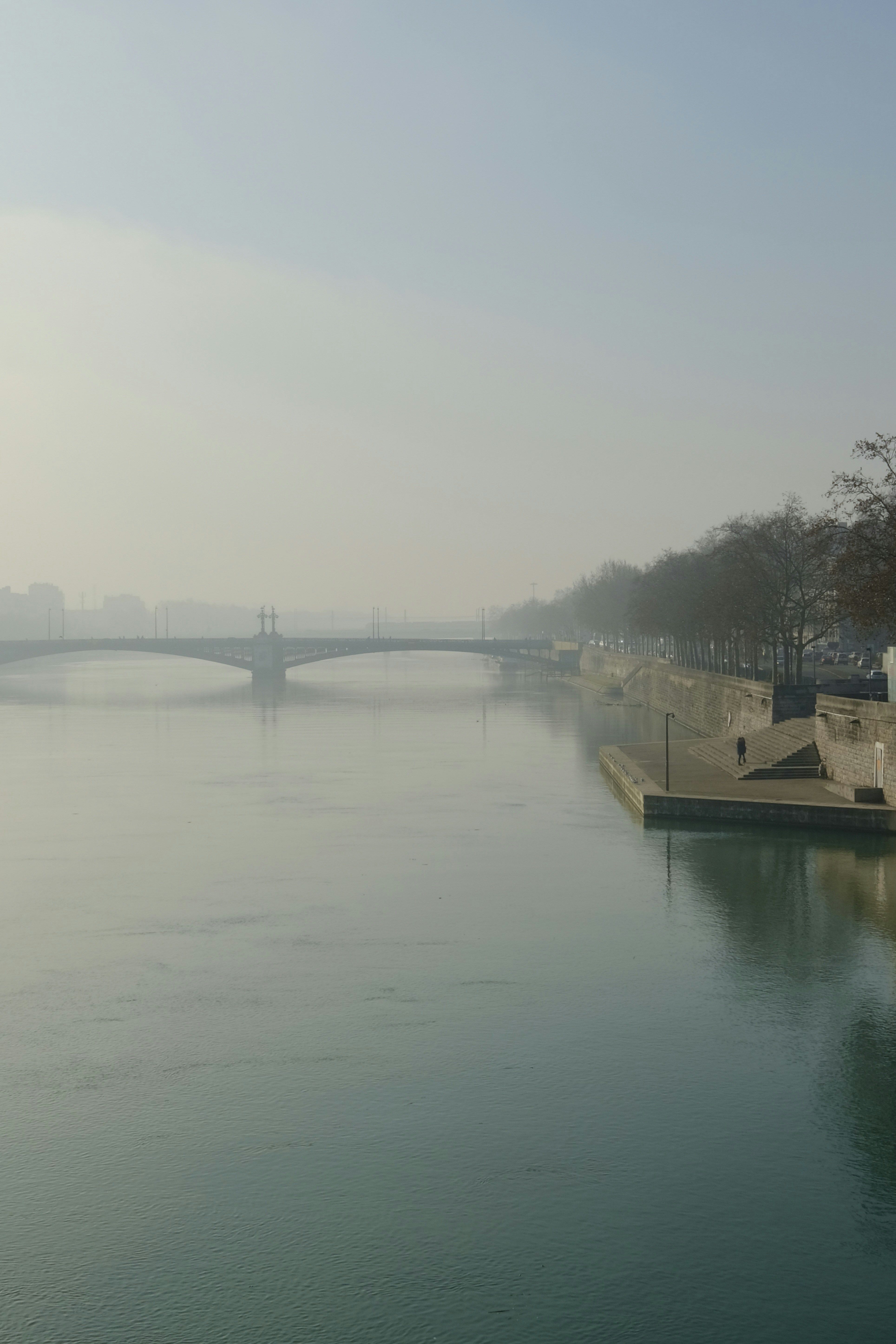 a body of water with a bridge in the background