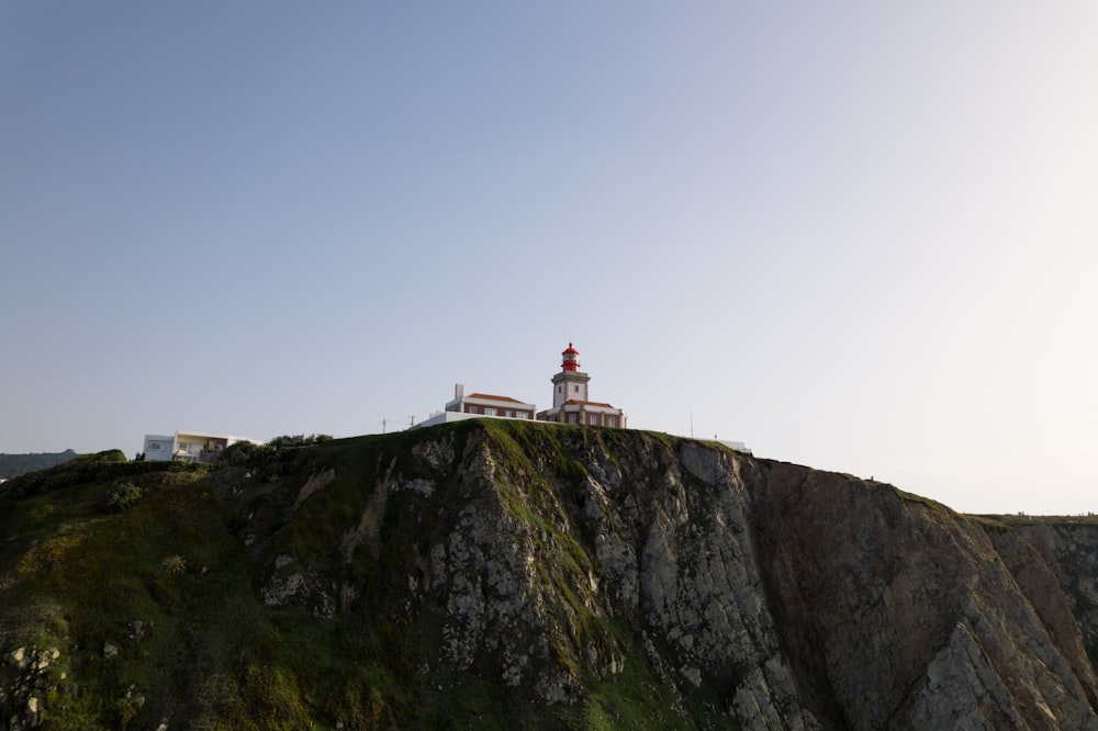 a lighthouse on top of a cliff on a sunny day