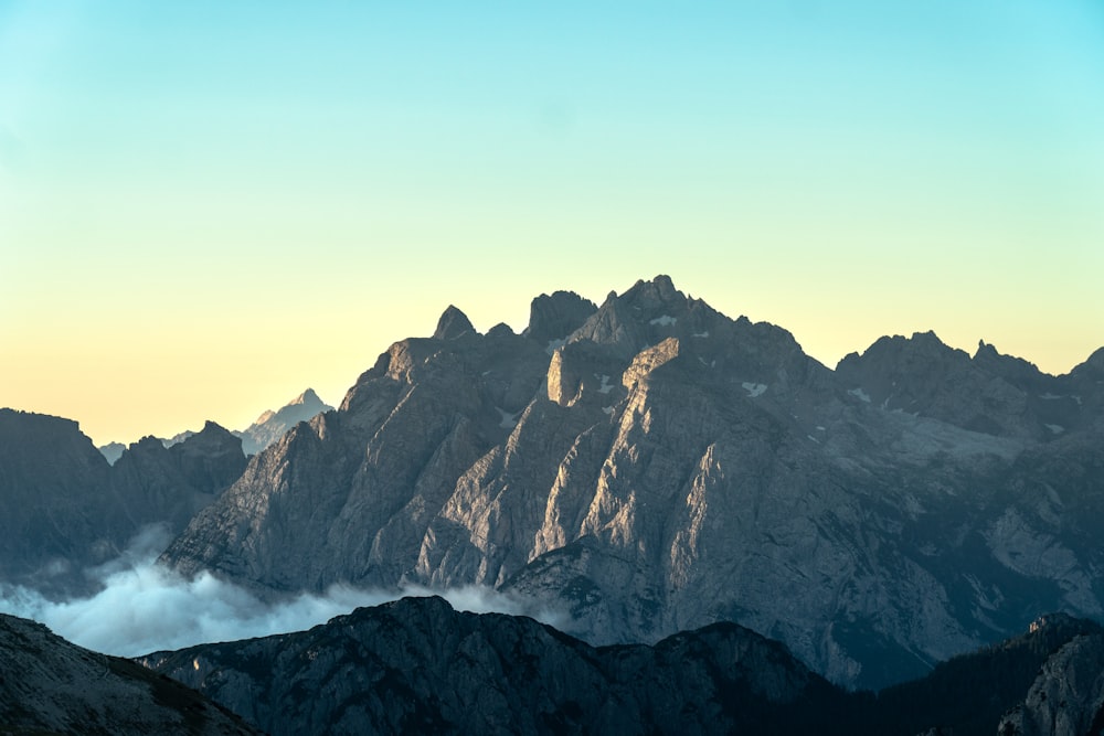 a view of a mountain range with clouds in the foreground