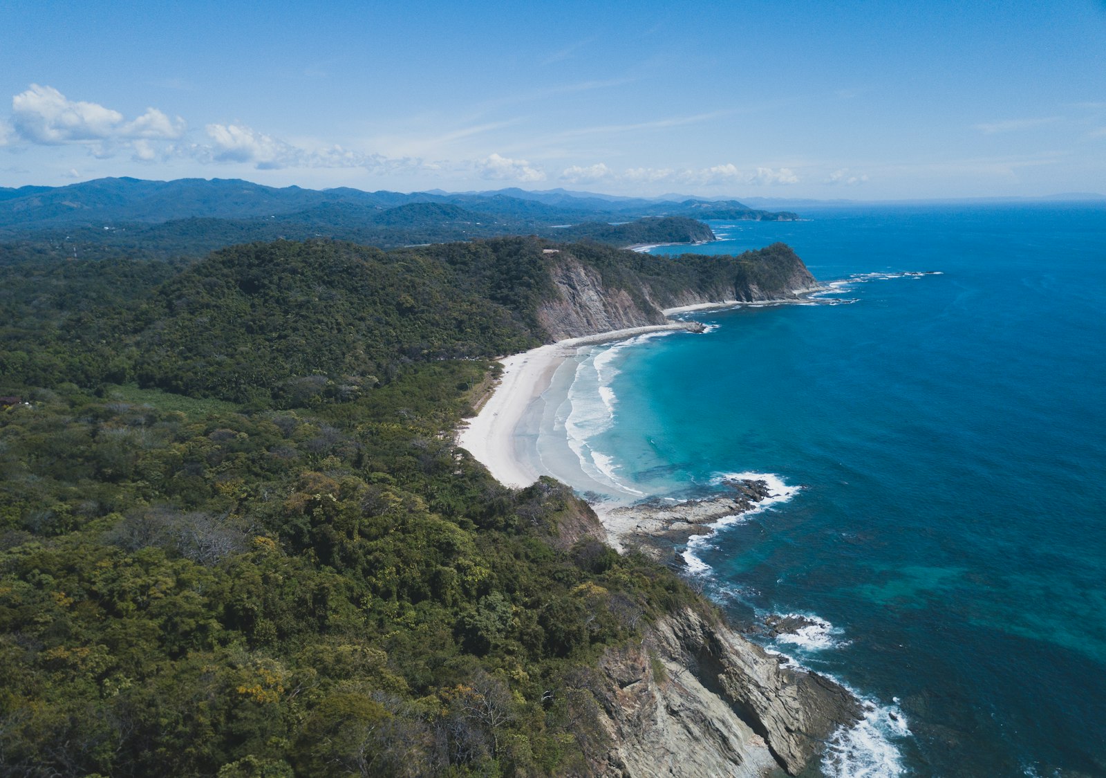 Aerial view of Playa Barrigona's empty sand beach and forested cliffs on the Nicoya Peninsula