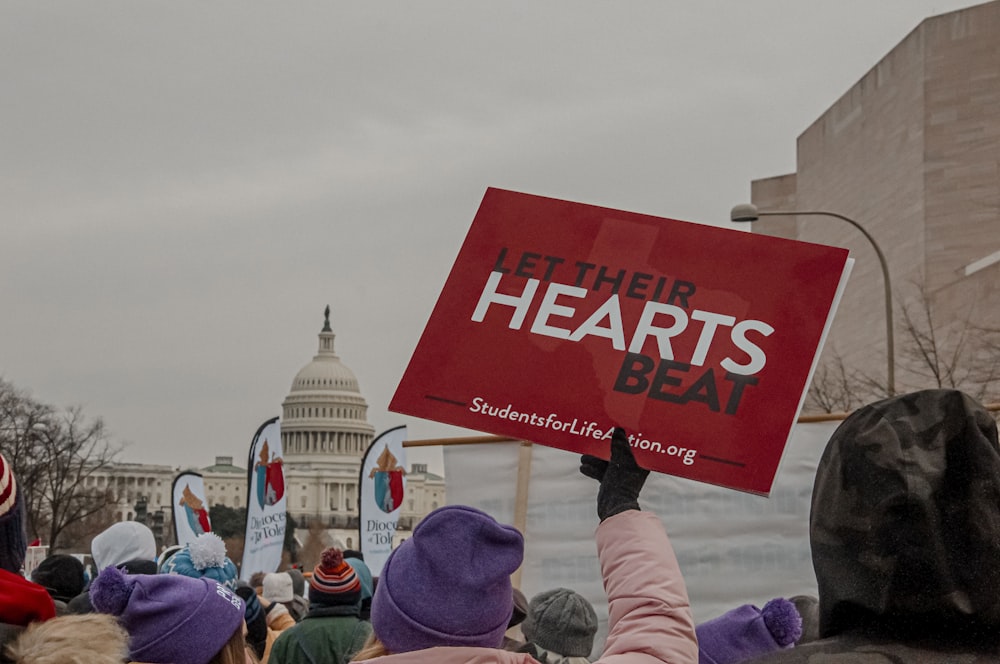 a group of people holding signs in front of the capitol building