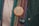 A close-up of two buttons pinned to a multicolored, textured fabric. The upper button is wooden with a design of a rose and the words 'TRY NONVIOLENCE' and 'REHUMANIZEINTL.ORG'. The lower button is black with '2,363 2363.ORG' in white text.