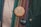 A close-up of two buttons pinned to a multicolored, textured fabric. The upper button is wooden with a design of a rose and the words 'TRY NONVIOLENCE' and 'REHUMANIZEINTL.ORG'. The lower button is black with '2,363 2363.ORG' in white text.