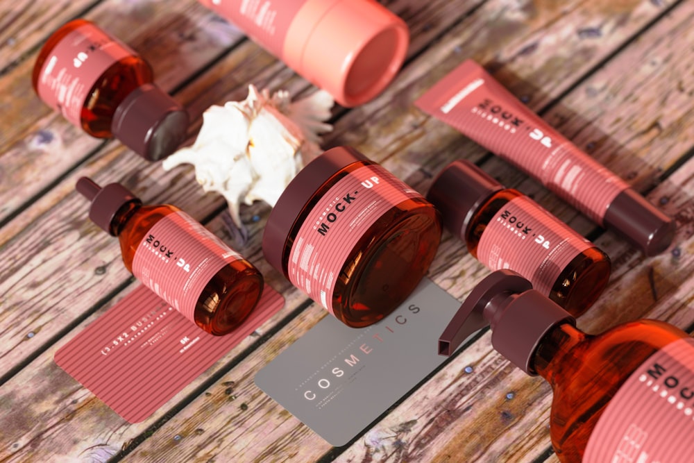 a group of brown and pink bottles sitting on top of a wooden table