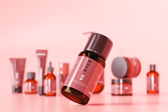 a group of bottles of skin care products on a pink background