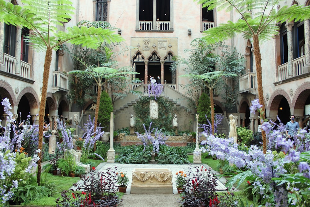 a courtyard with a fountain surrounded by trees and flowers