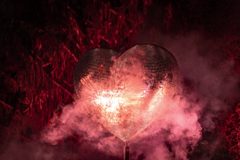 a heart - shaped object is surrounded by smoke