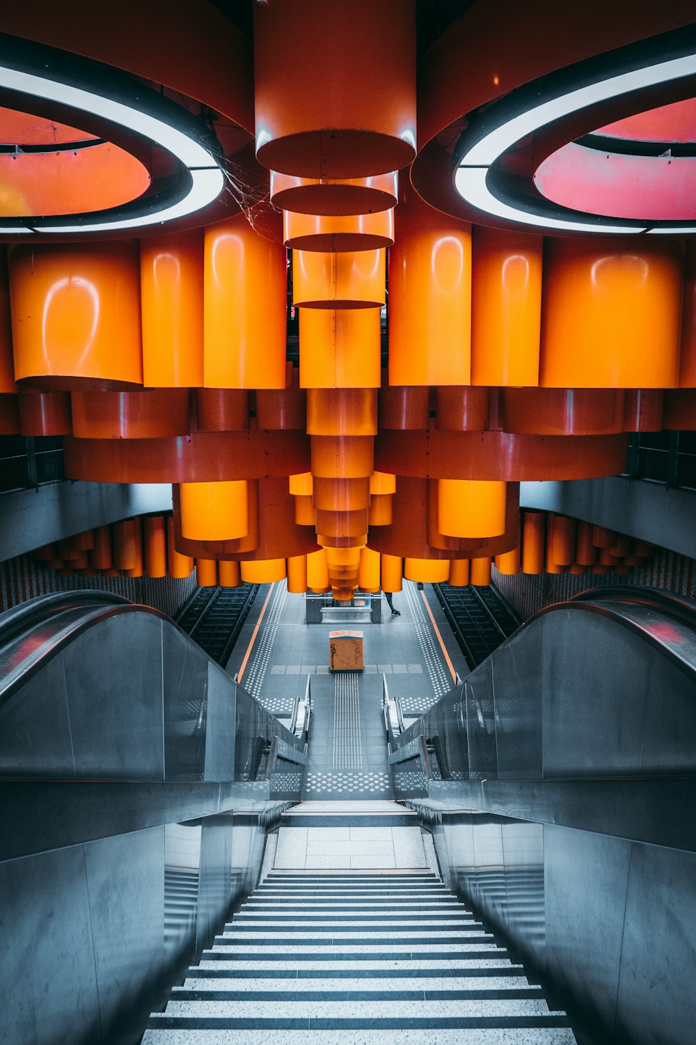 an escalator in a building with orange lights