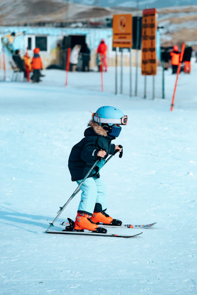 a young child riding skis down a snow covered slope