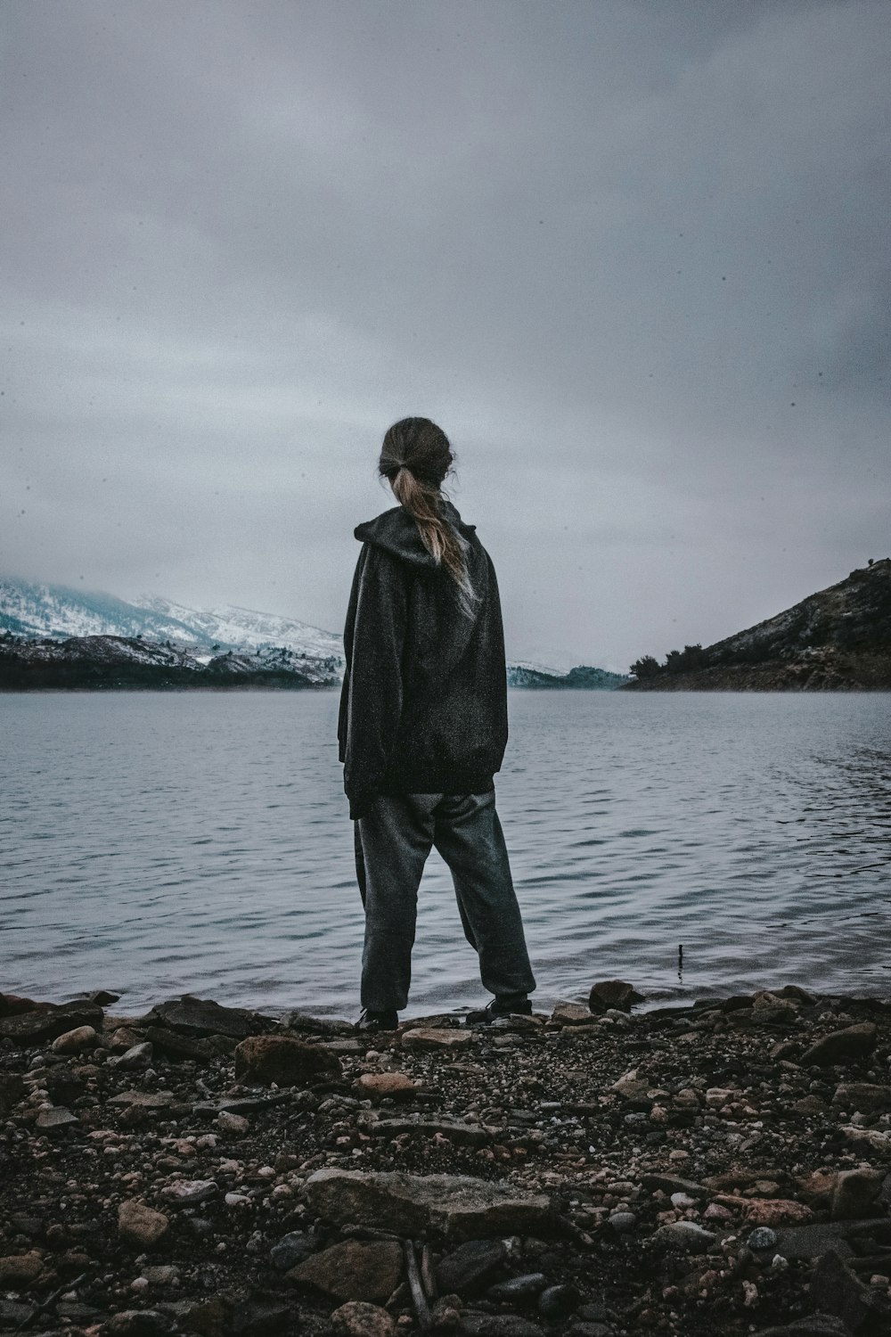 a person standing on the shore of a lake