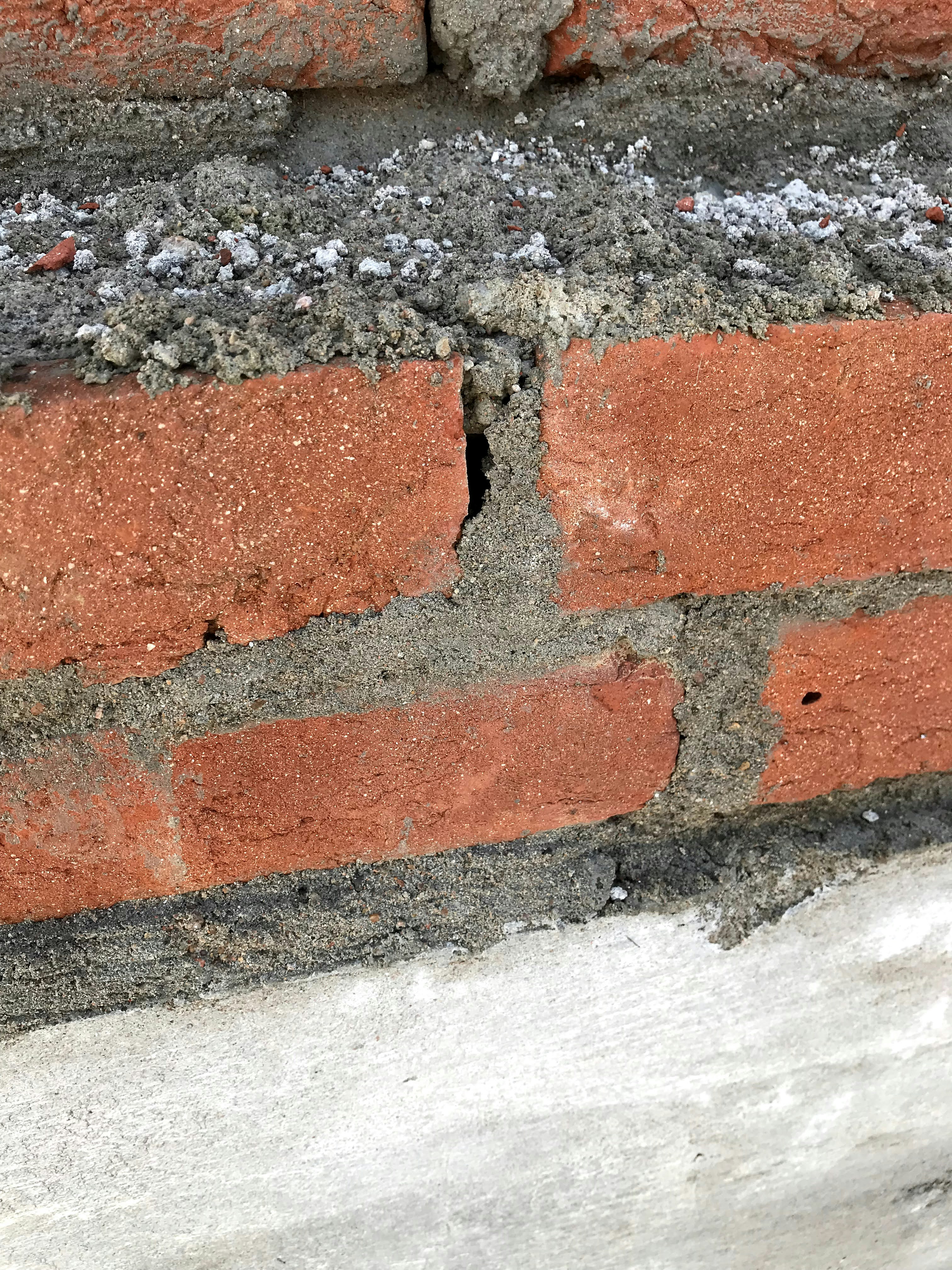 Close-up of cracked concrete wall showing structural damage in an old building.