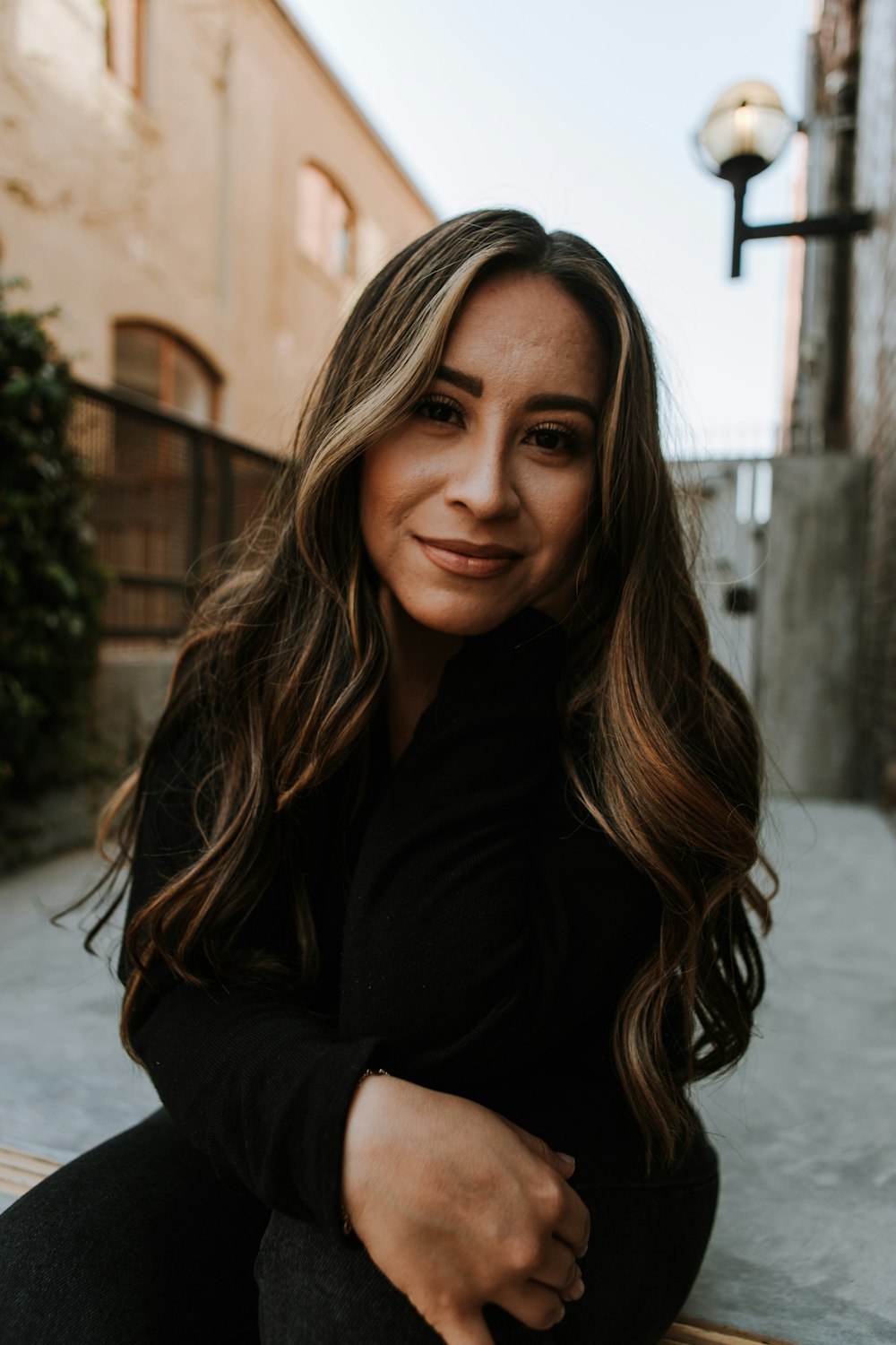 a woman is sitting on a bench smiling