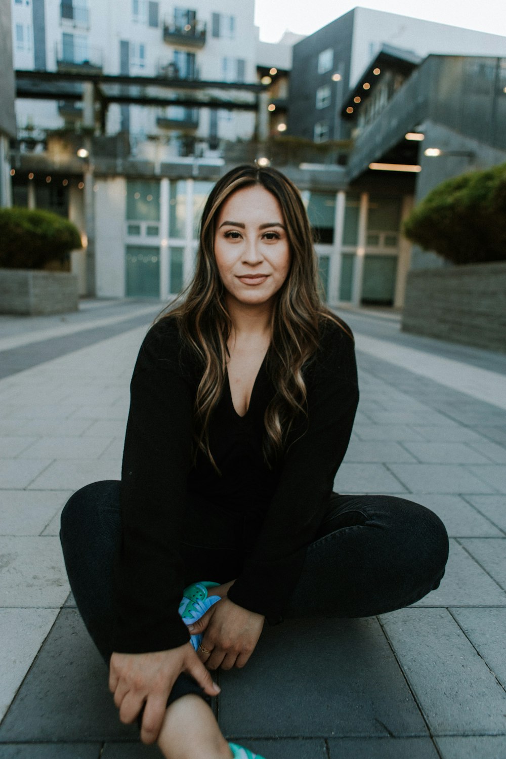 a woman sitting on the ground with her legs crossed