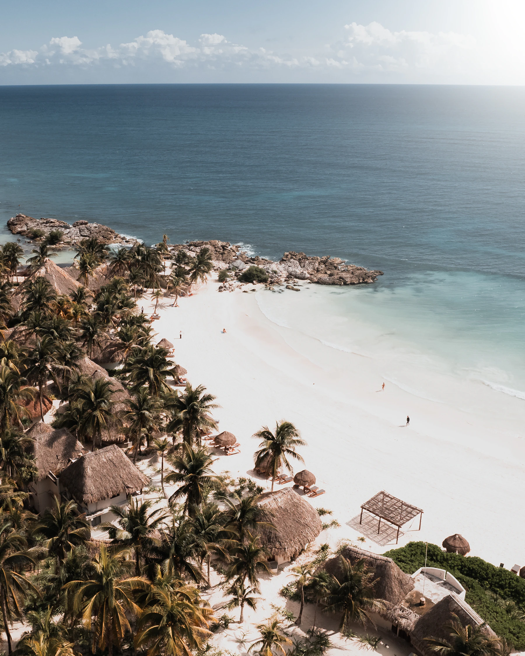 Aerial view of a reef-sheltered Caribbean bay lined with palm trees, near Tulum, Mexico