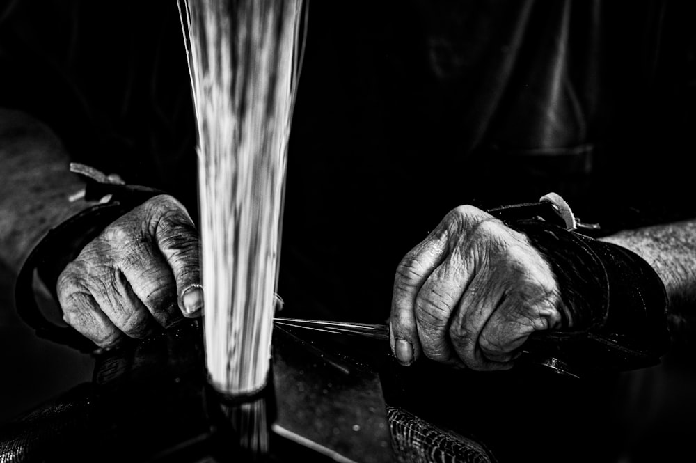 a black and white photo of a person holding a pair of scissors