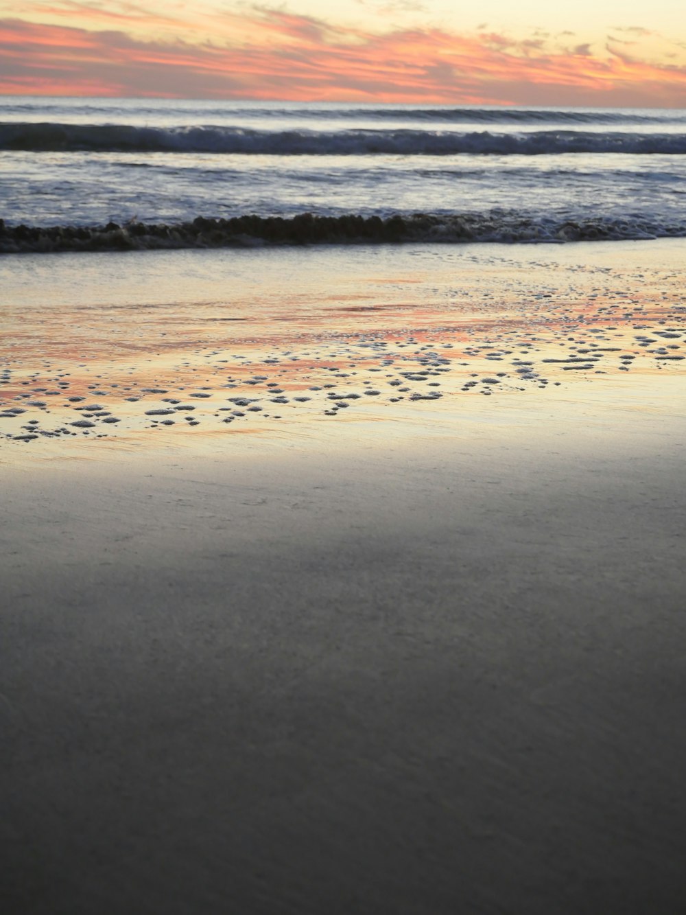 a person walking on a beach with a surfboard