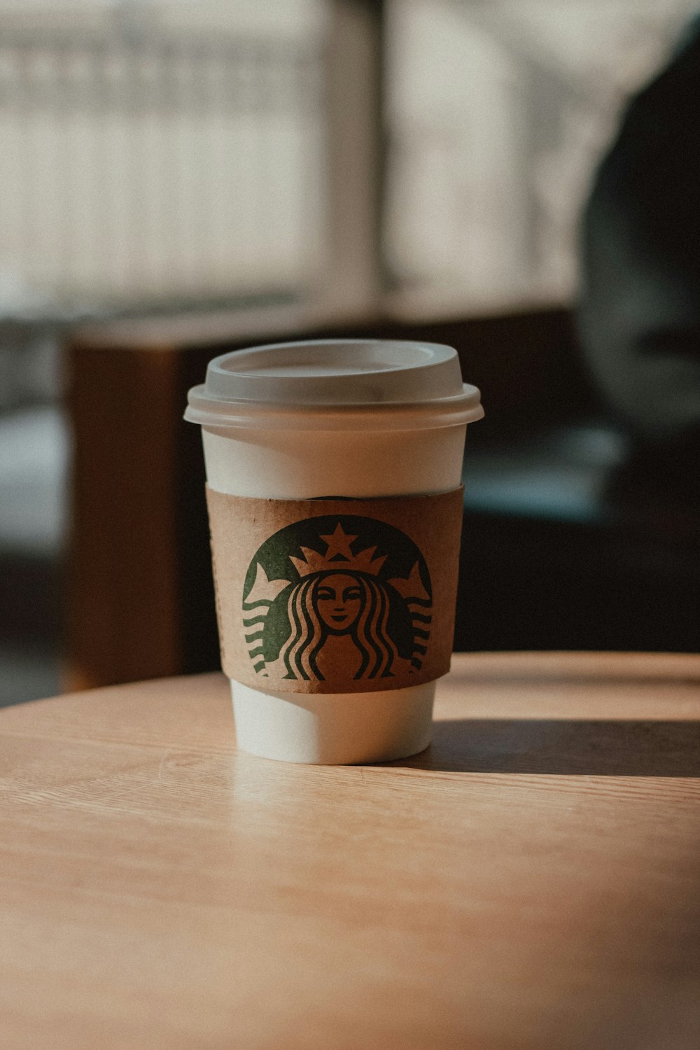 a starbucks cup sitting on top of a wooden table