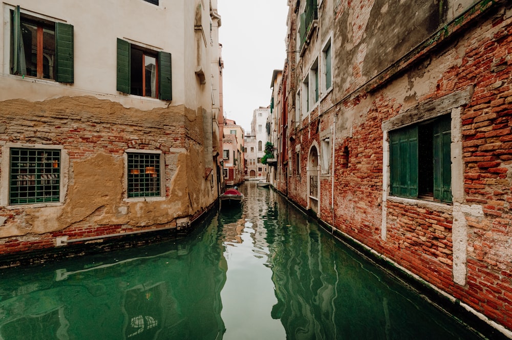 a narrow canal running between two buildings in venice