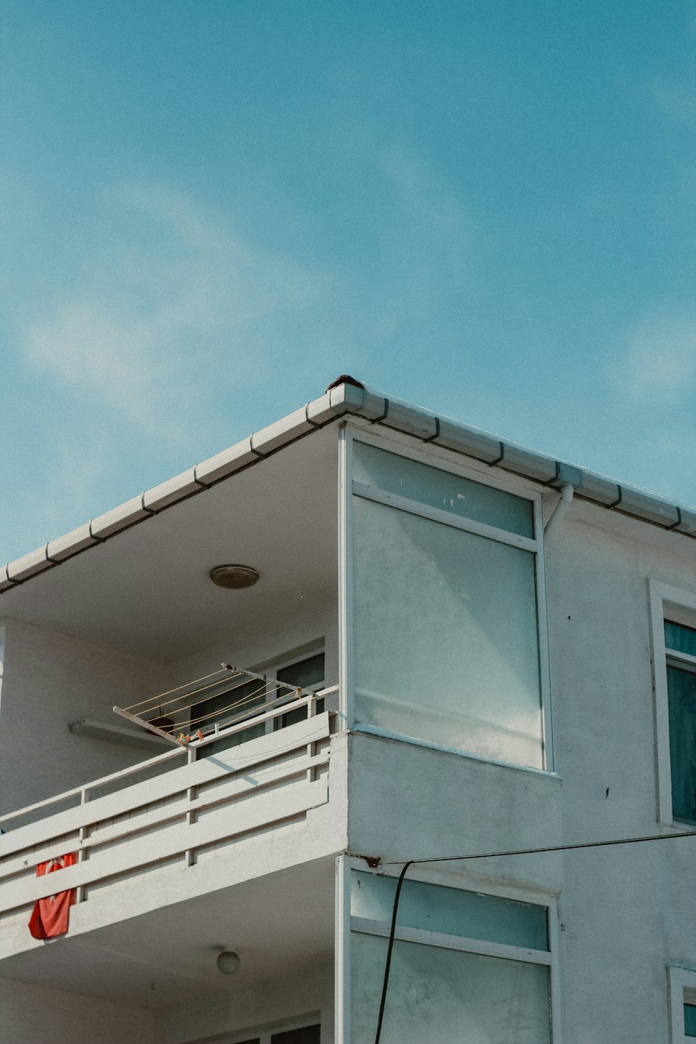 a tall white building with a balcony and balconies