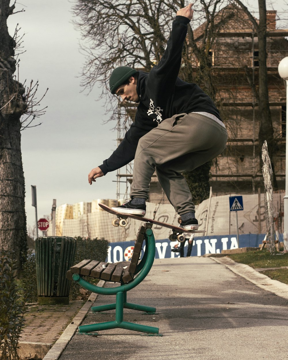 a man on a skateboard jumping over a bench