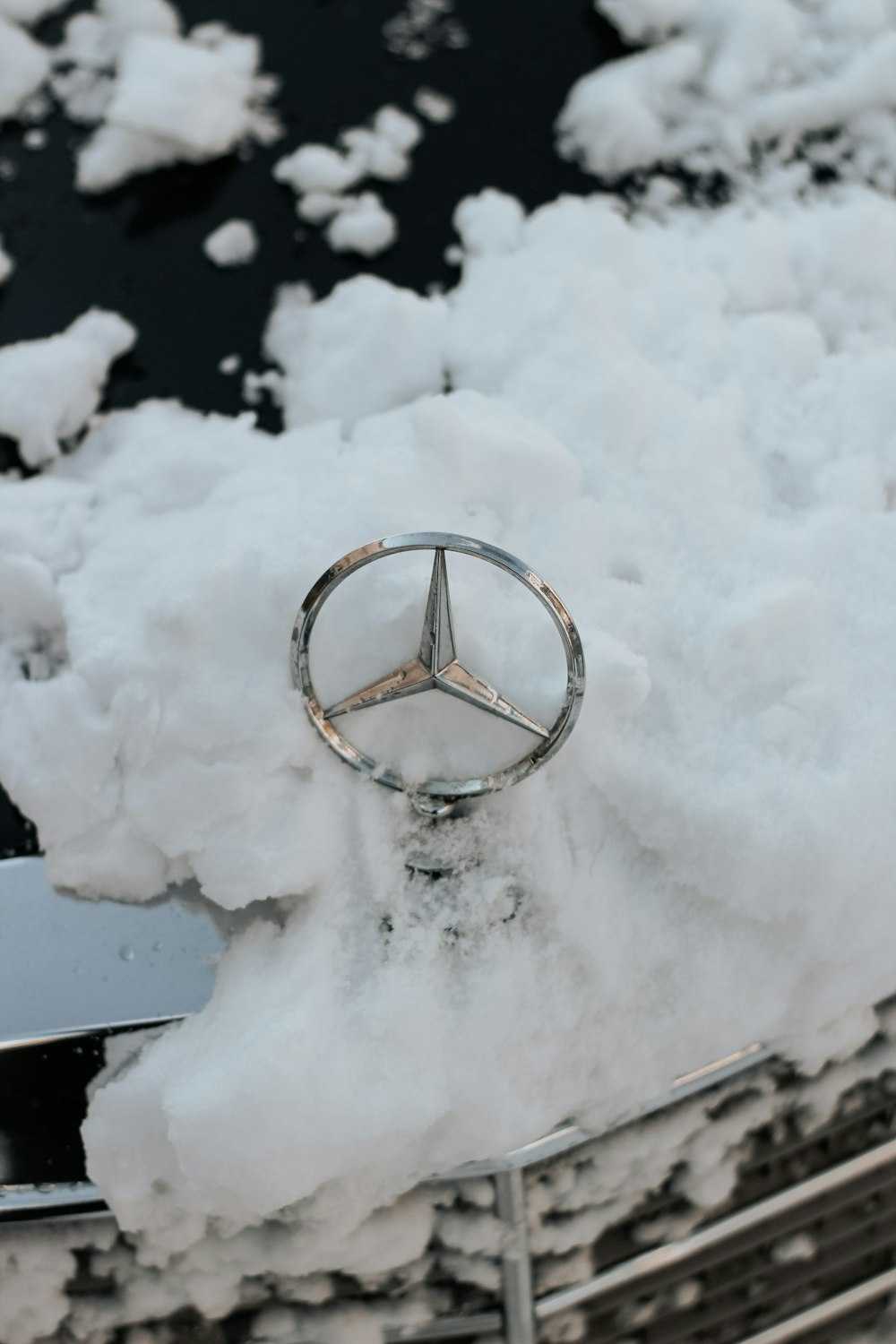 a mercedes emblem is covered in snow and ice