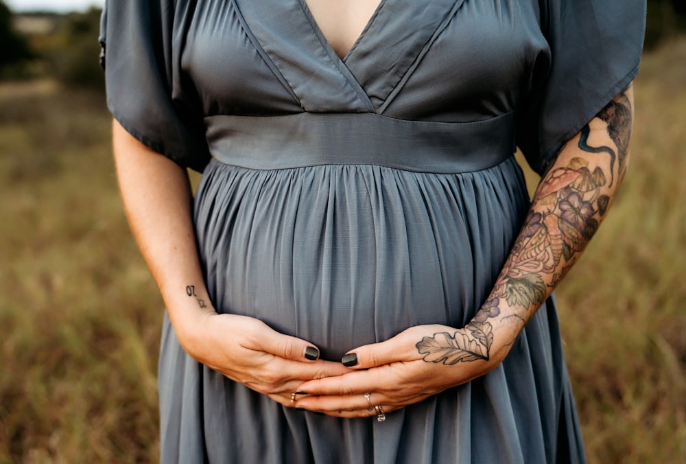 a pregnant woman in a dress holding her belly