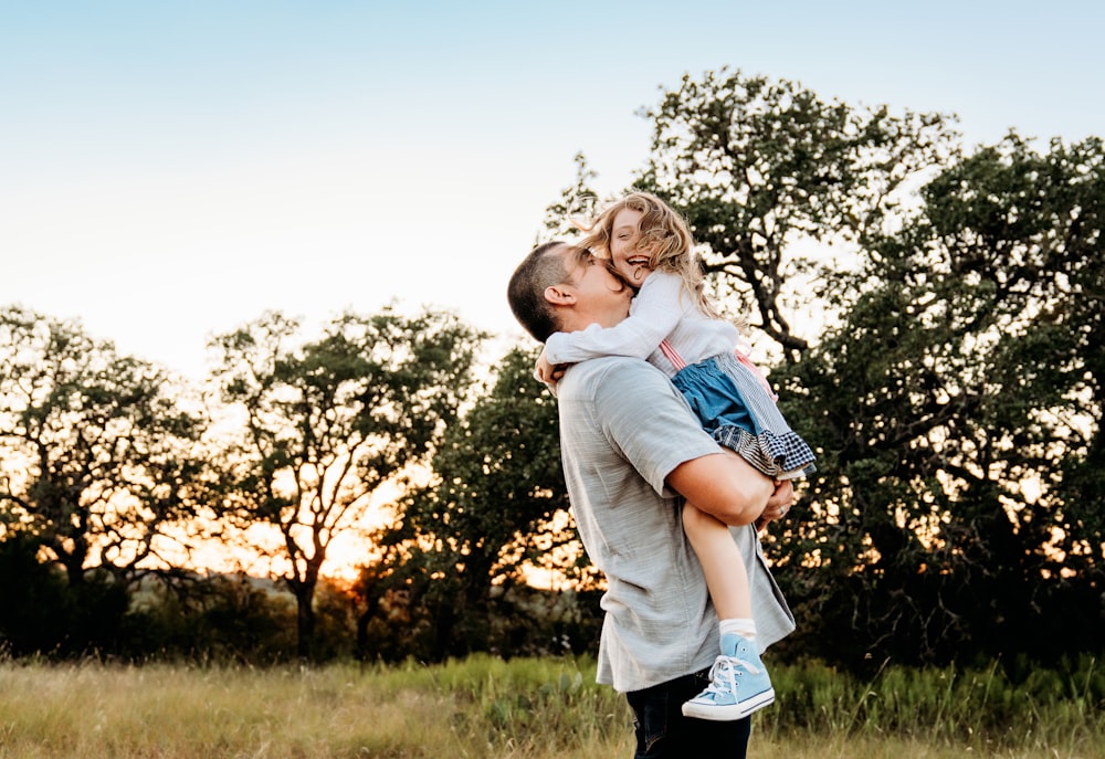 a man holding a little girl in his arms