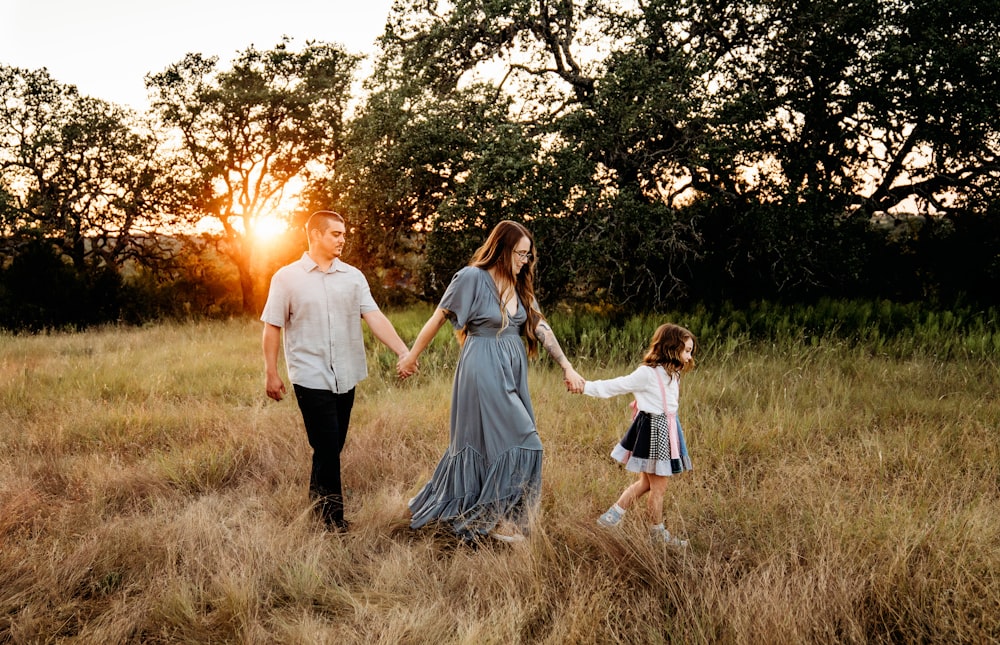 a family walking through a field holding hands