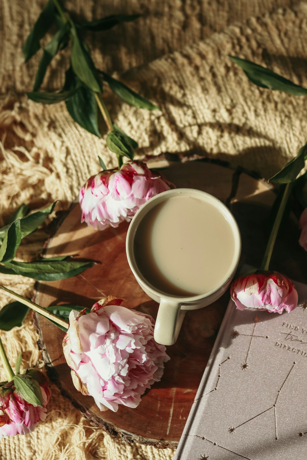 a cup of coffee and some pink flowers