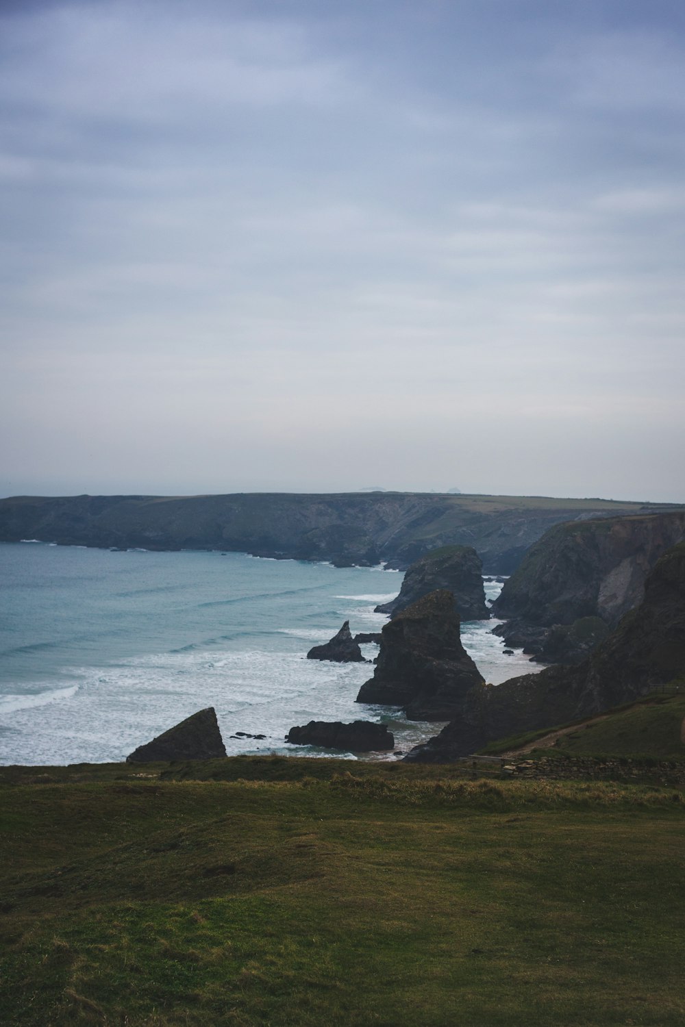 a large body of water sitting next to a lush green hillside