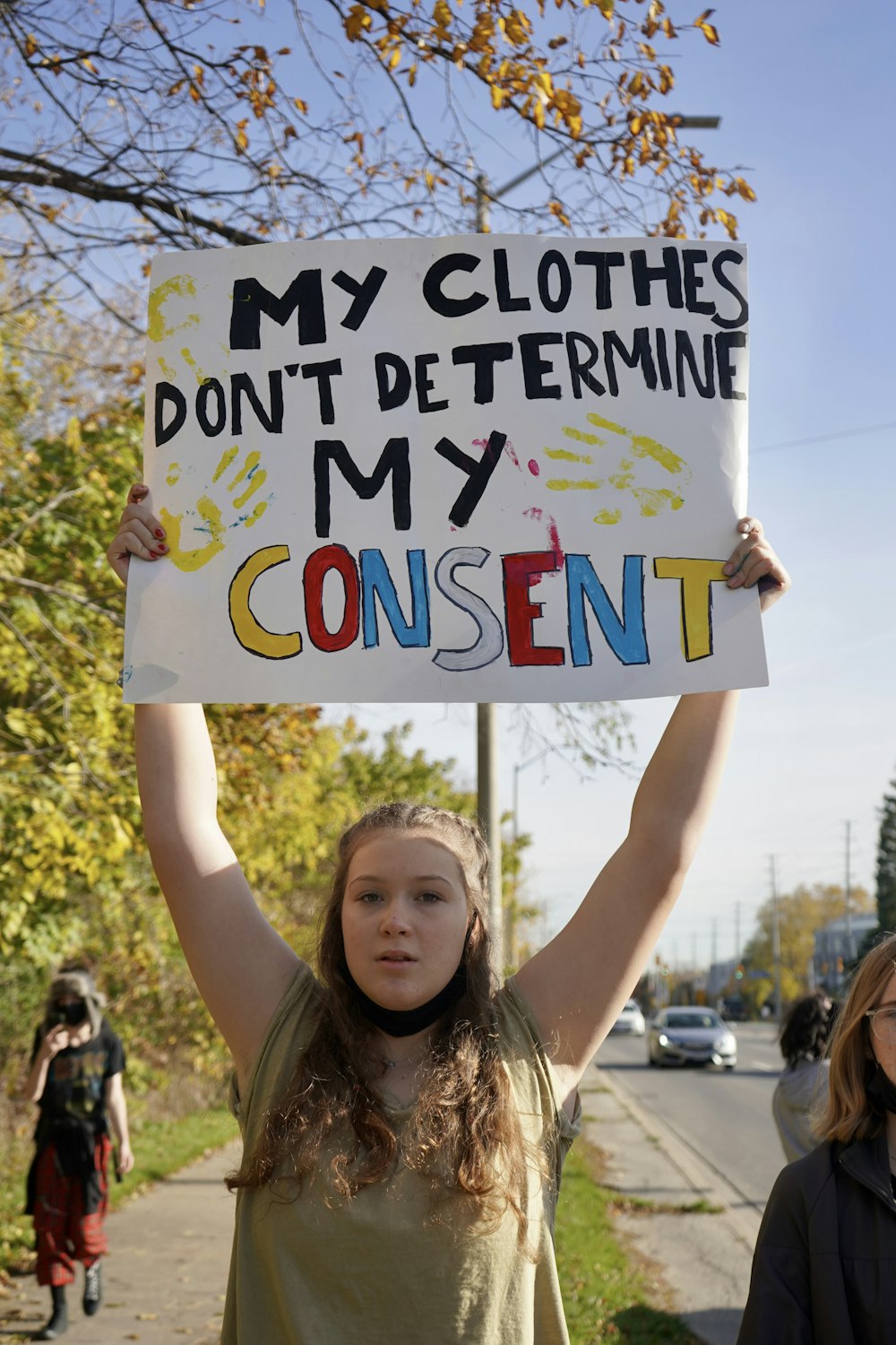 a girl holding a sign that says, my clothes don't determine my content