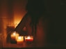 A peaceful bathroom scene with soft candlelight and a jar of Moon Child bath brew beside a steaming bathtub.