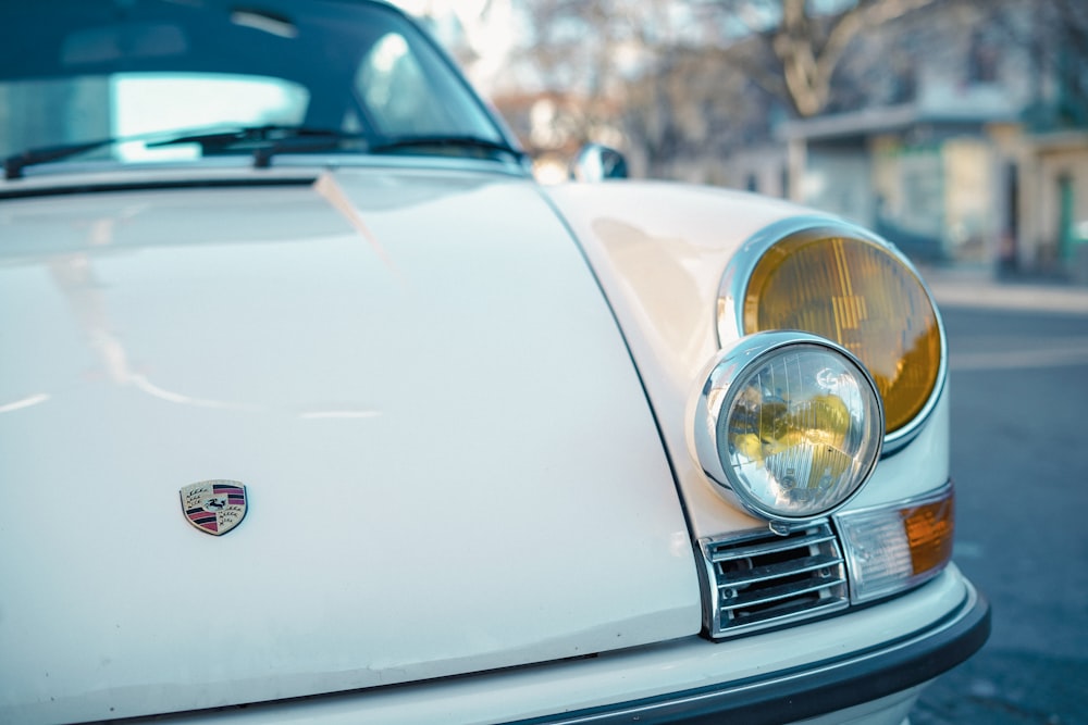 a close up of a white car parked on the side of the road