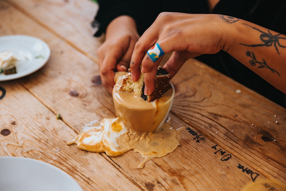 a person sitting at a table with food in a glass