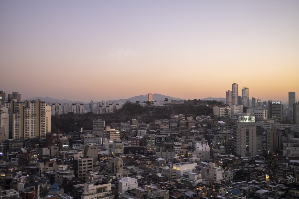 a view of a city at sunset with mountains in the background