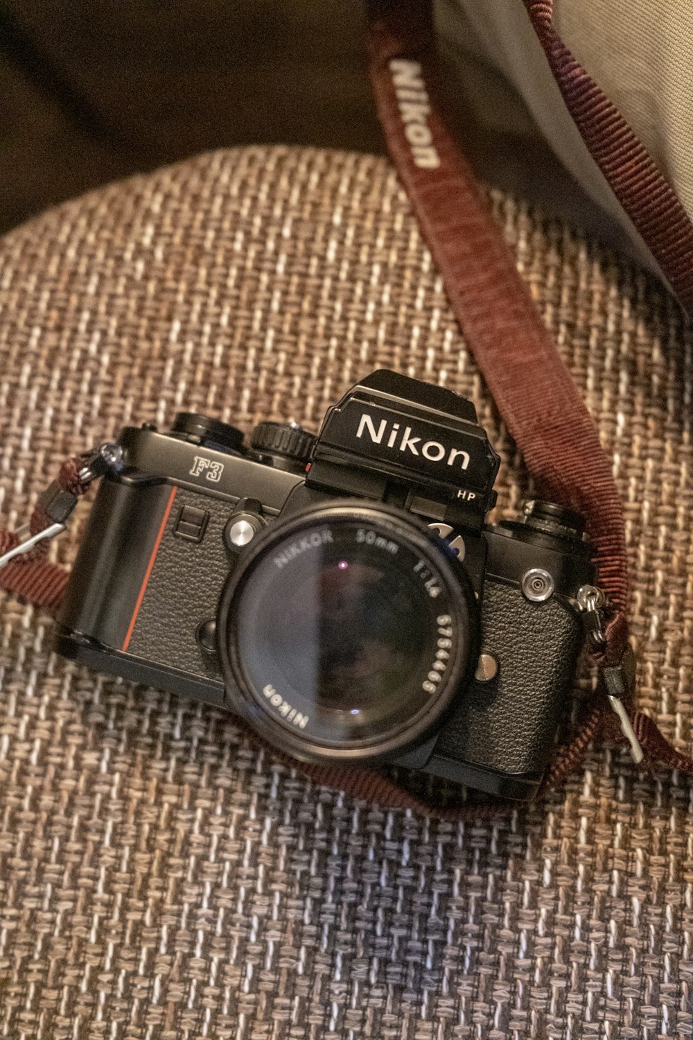 a camera sitting on top of a couch next to a pillow