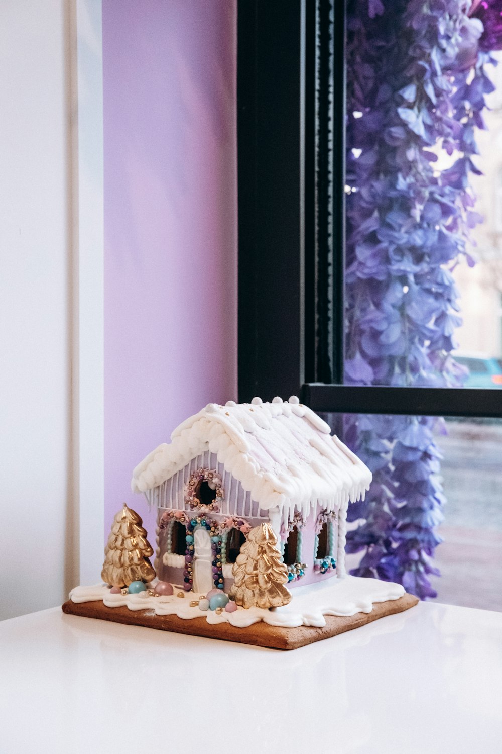 a gingerbread house on a table in front of a window