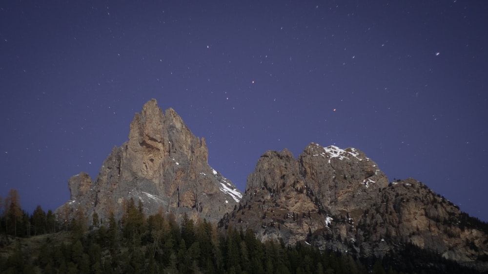 the night sky over a mountain range with stars in the sky