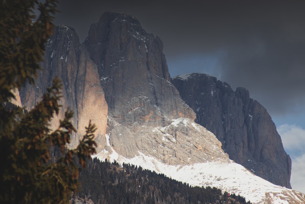 a snow covered mountain with trees in the foreground