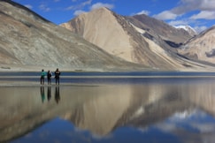 a group of people standing on top of a lake