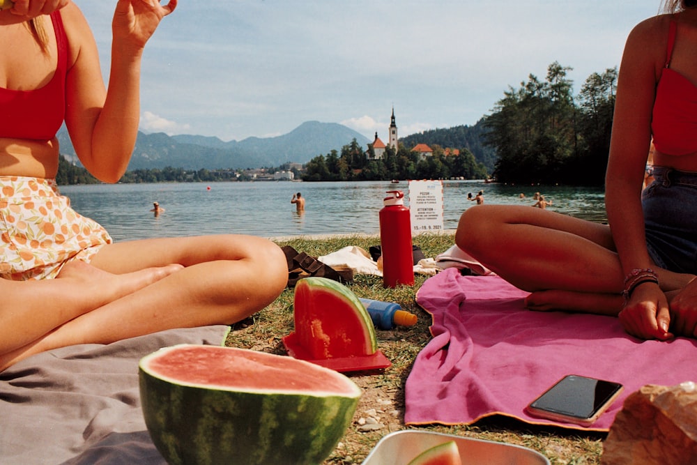 a couple of women sitting next to each other on a beach