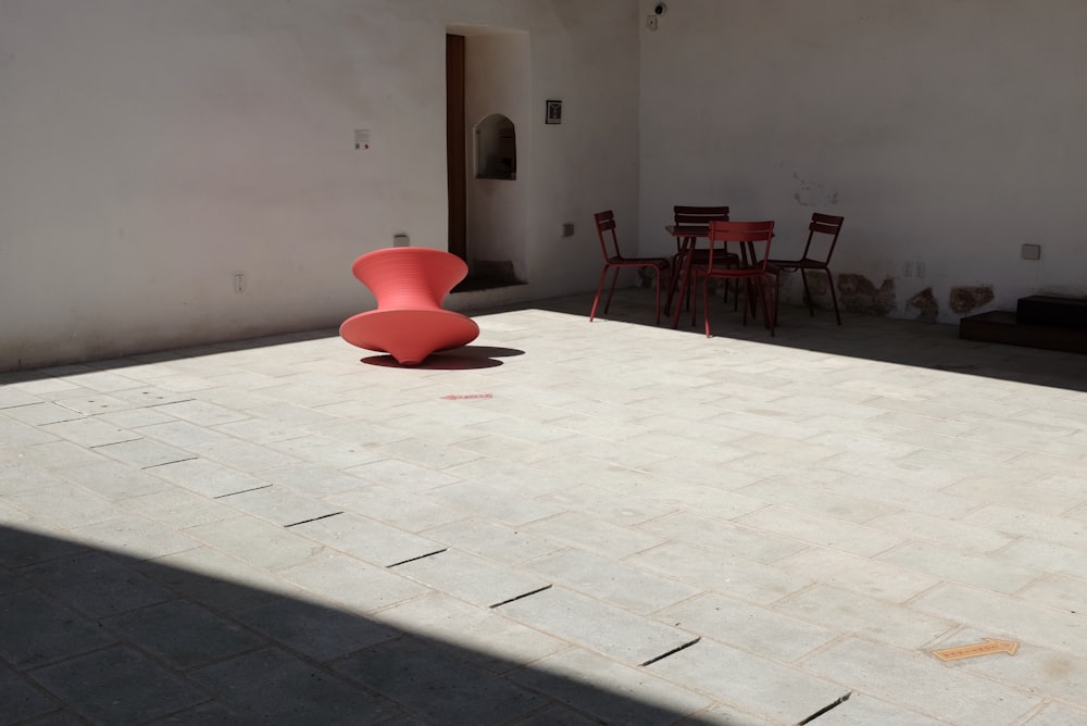 Una silla roja sentada encima de un piso blanco